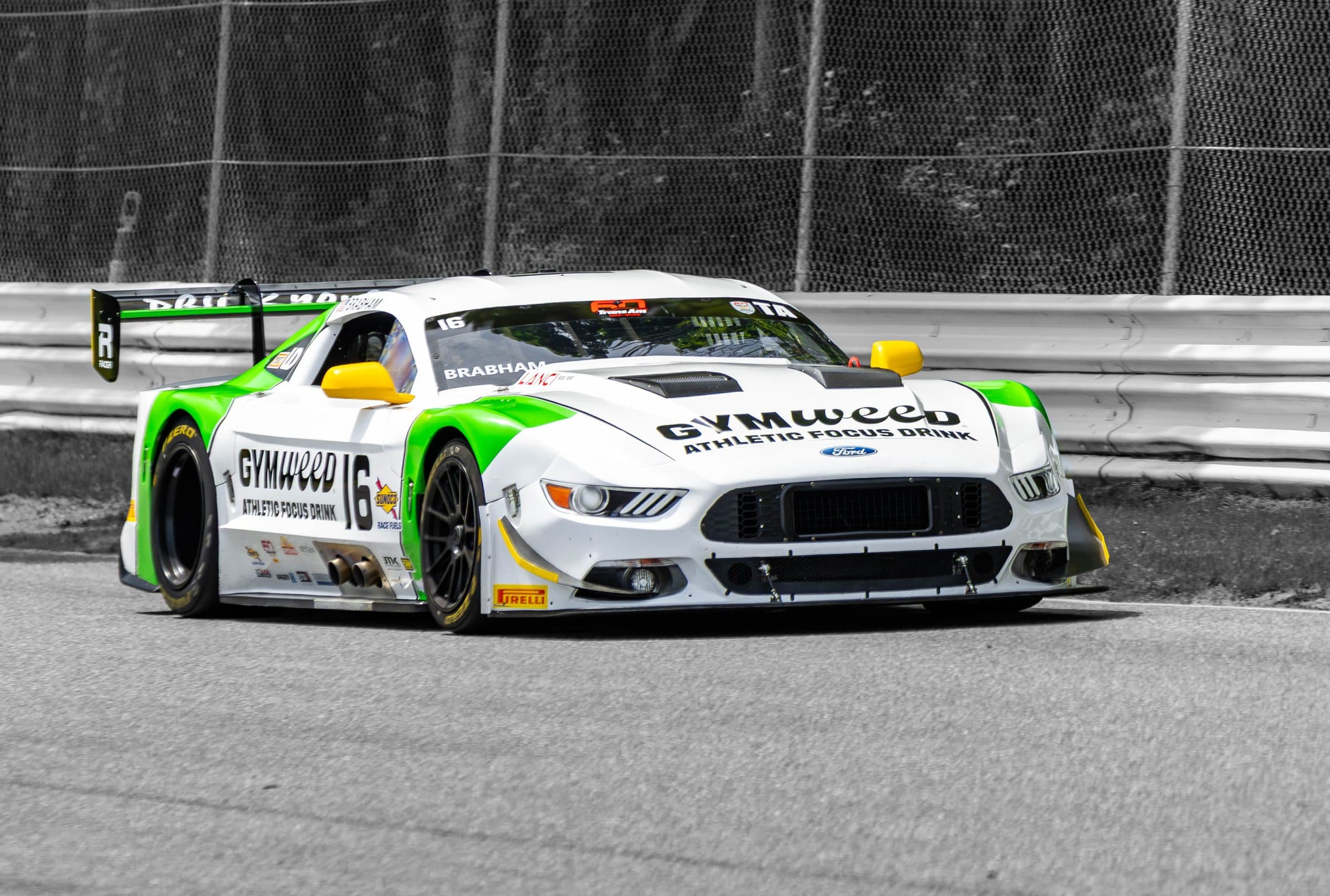 The green-and-white GYMweed Mustang and the black-and-gold Trench Shoring Camaro, shot back to back through the same stretch of track.